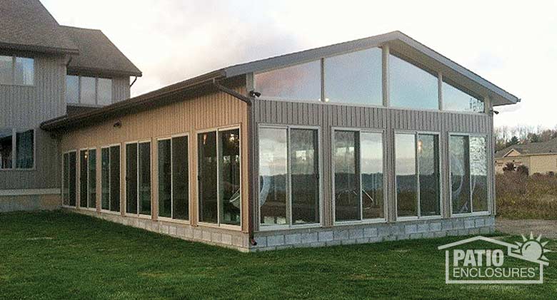 Traditional sunroom with sandstone frame and gable roof provides shelter for an indoor pool.