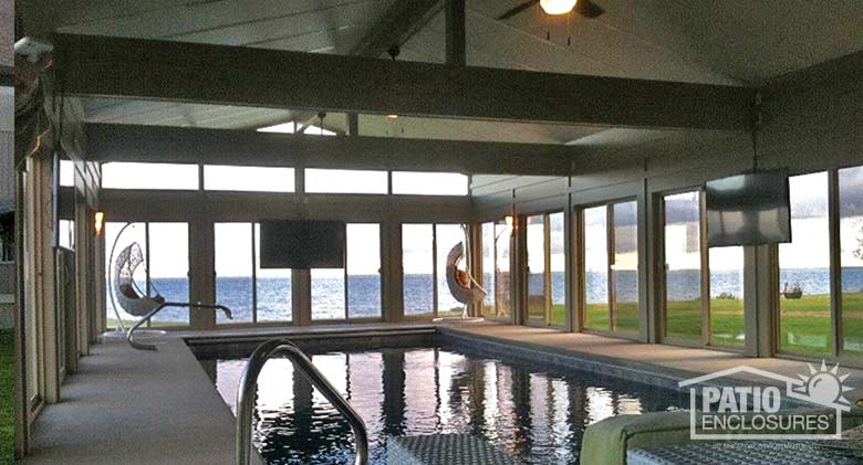 Traditional sunroom with sandstone frame and floor-to-ceiling glass for expansive lake views.