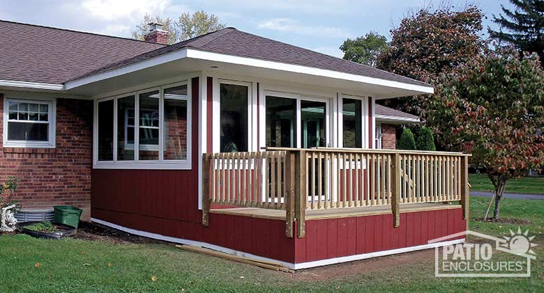 Traditional sunroom with white vinyl frame, solid knee wall and hip roof.