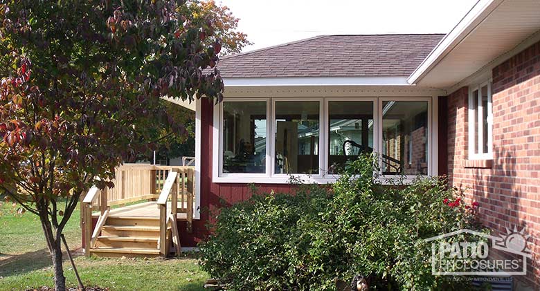 Traditional sunroom with white vinyl frame, solid knee wall and hip roof.