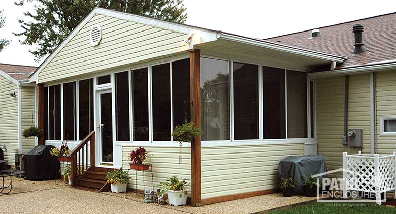 Traditional sunroom with white aluminum frame, solid knee wall and gable roof.