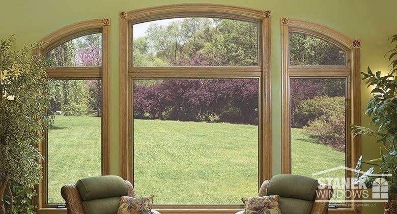 Casement windows flank a picture window with custom-shaped windows above for an expansive view.