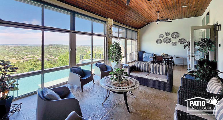 In this Florida room, a spacious seating area with cushioned furniture provides views of the outdoor pool and beyond.