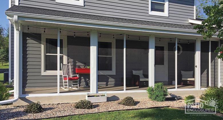 A screened-in covered porch across the back of a gray house