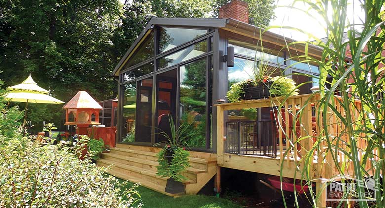 Bronze four season sunroom with aluminum frame, transoms and gable roof.