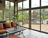 Virtually invisible screened walls of a patio enclosure provide guard against bugs but allow views of the deck and backyard.