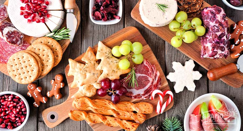 Festive holiday snacks of crackers, fruit, cheese, meat, cookies, and candy canes.