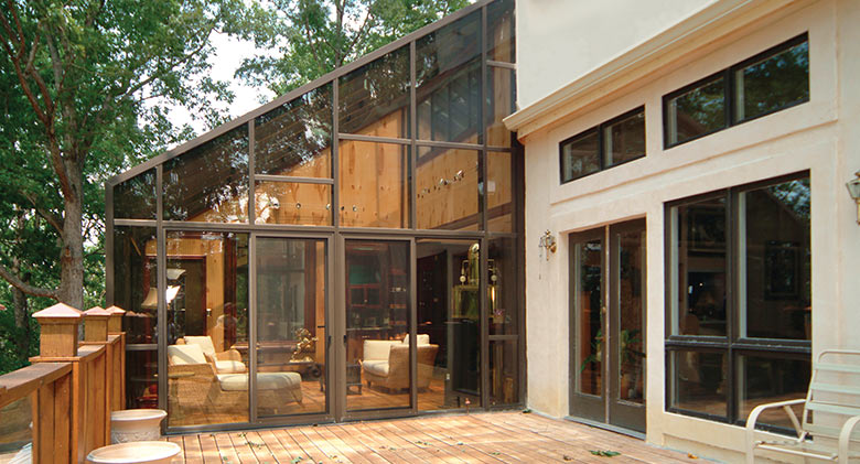 A bronze solarium with single-slope glass roof is a year-round living space.