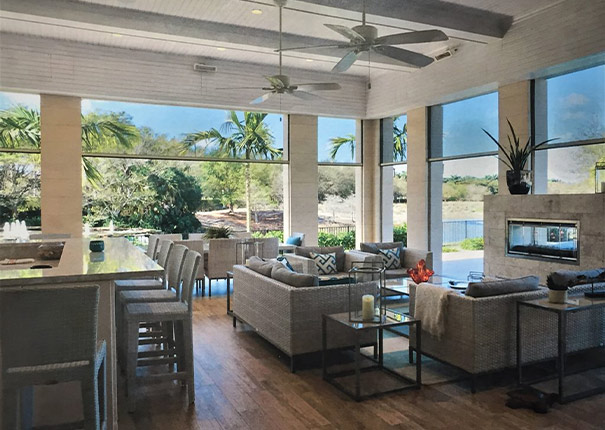 A covered patio is turned into an all-purpose entertainment room with retractable screens covering the openings.
