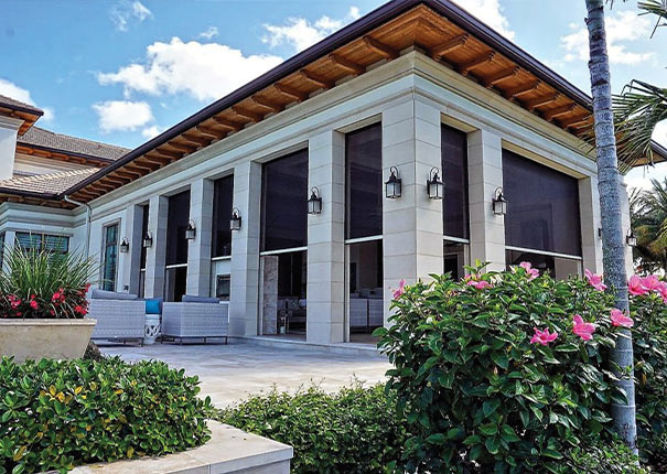 A covered patio with stone columns and lights. The openings are protected by retractable screens shown halfway down.
