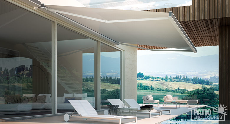 Chaise lounge chairs poolside with a white retractable awning extended overhead.