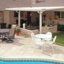 Three-season Elite glass sunroom with sandstone frame and solid knee wall.