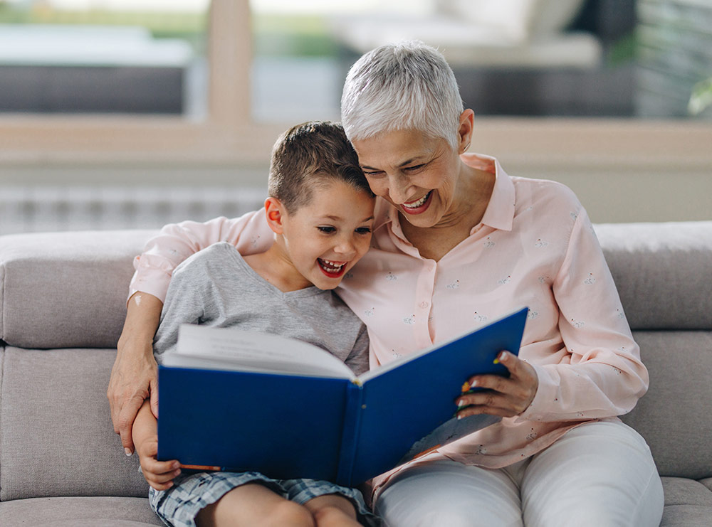older lady reading a book to a young kid